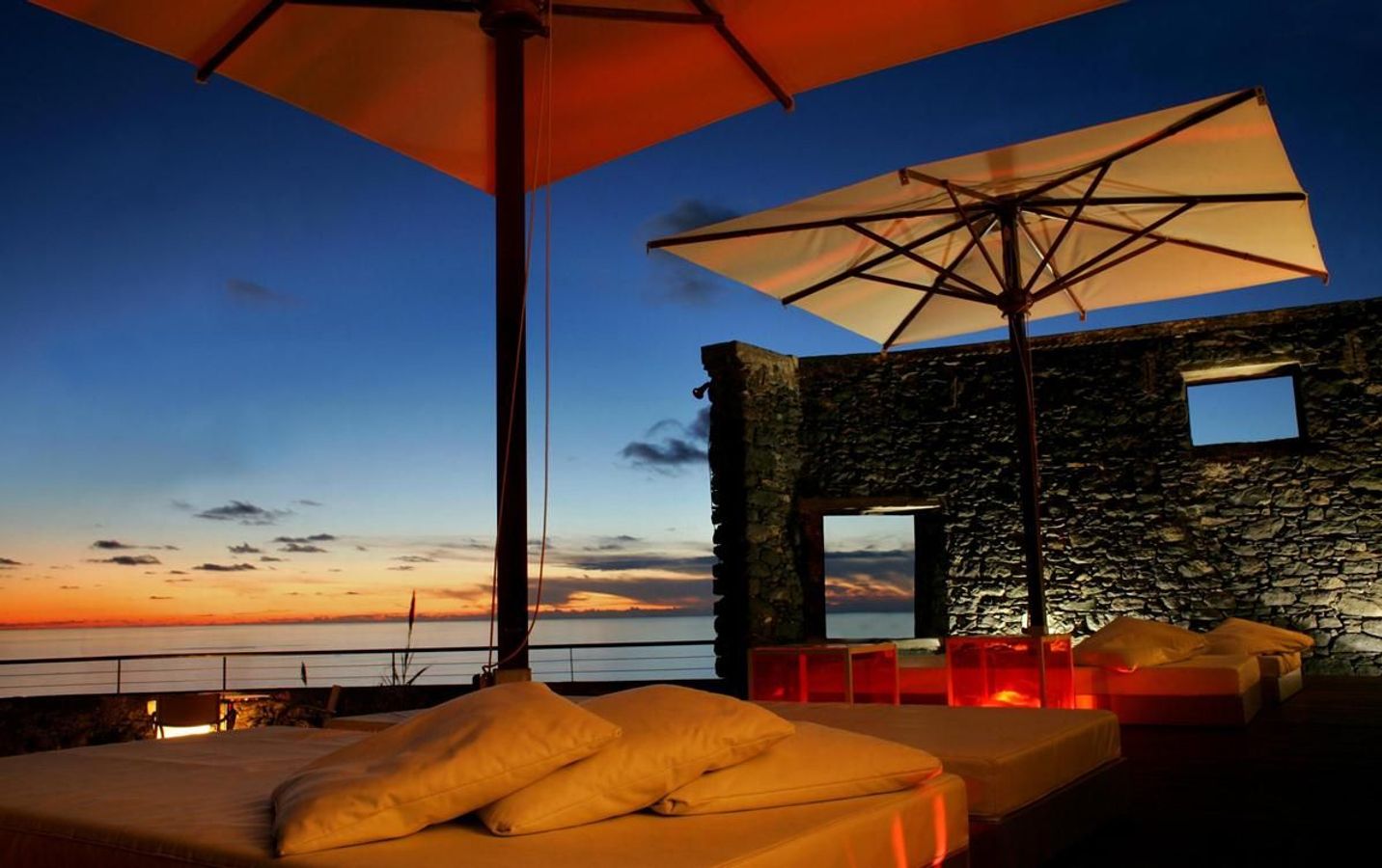 Kveldsstemning fra terrassen på hotellet Estalagem Ponta do Sol i Ponta do Sol. Terassen har behagelige senger med store puter, plassert under brede parasoller.