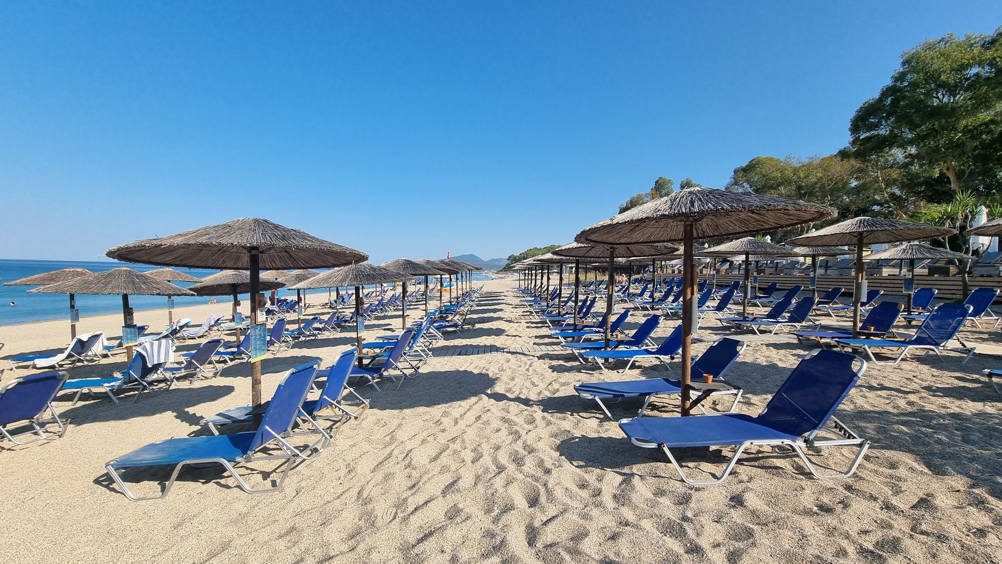 Utsikt over en deilig sandstrand med solstoler og parasoller i Preveza i Hellas
