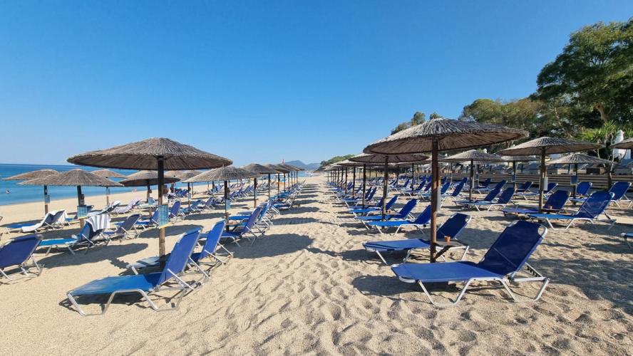 Utsikt over en deilig sandstrand med solstoler og parasoller i Preveza i Hellas