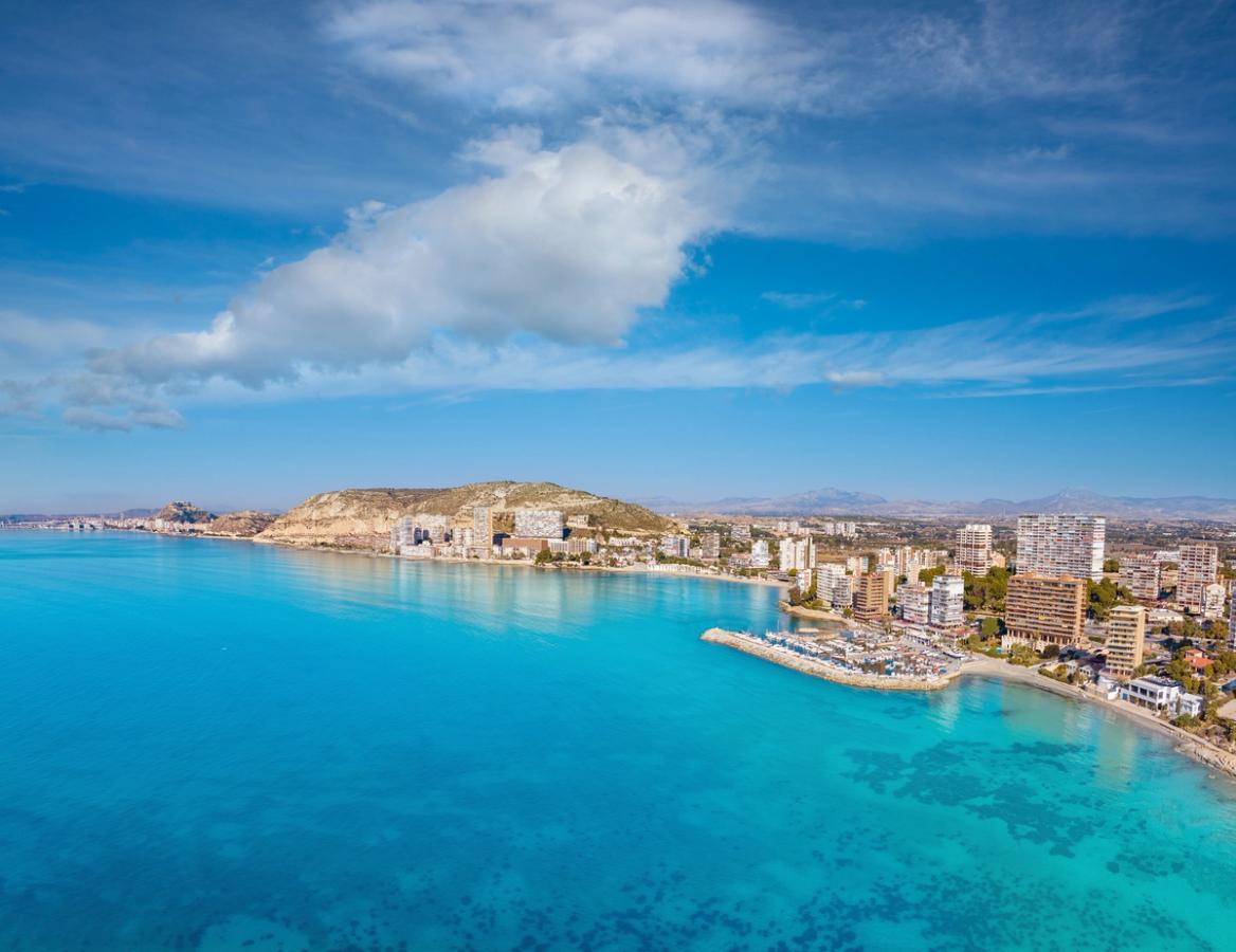 Utsikt mot Alicante från havet, med den långa stadsstranden Playa Albufereta framför bebyggelsen