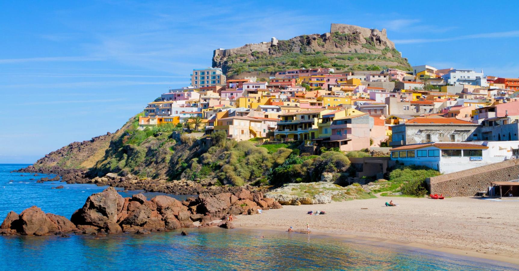 Utsikt over stranden og den fargerike byen Castelsardo på Sardinia