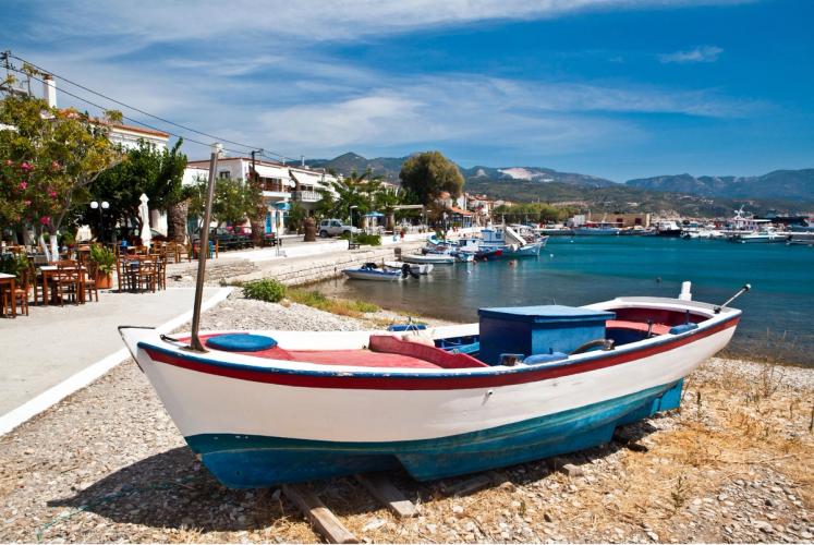 Udsigt over idylliske Ormos på Samos med små fiskerbåde og hovedgaden med hyggelige tavernaer.