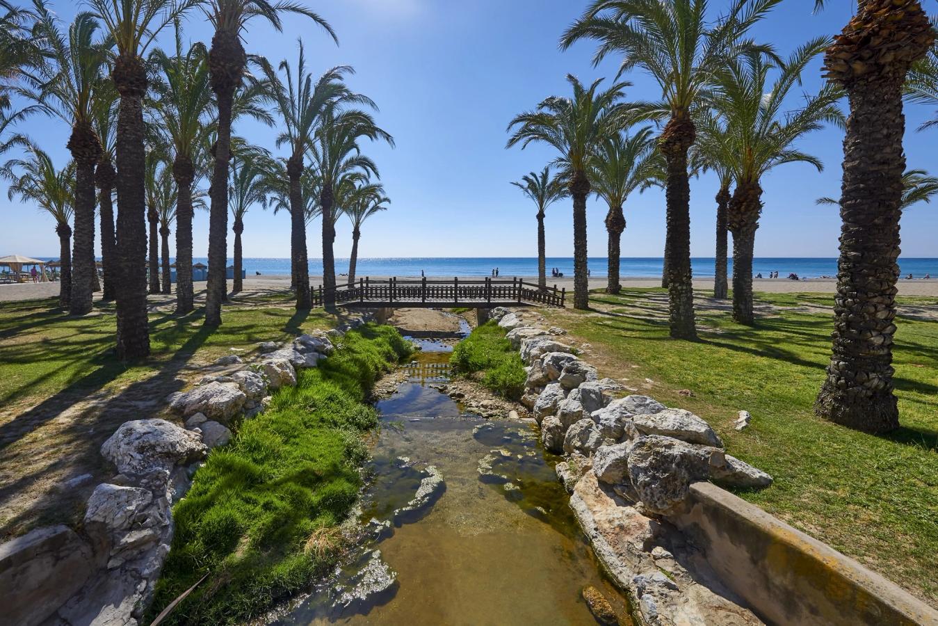 Smale kanaler som får vann i fra sjøen, og med frodig natur tett inntil, finnes på rekke og rad langs stranden i Torremolinos. Her med utsikt utover Middelhavet.