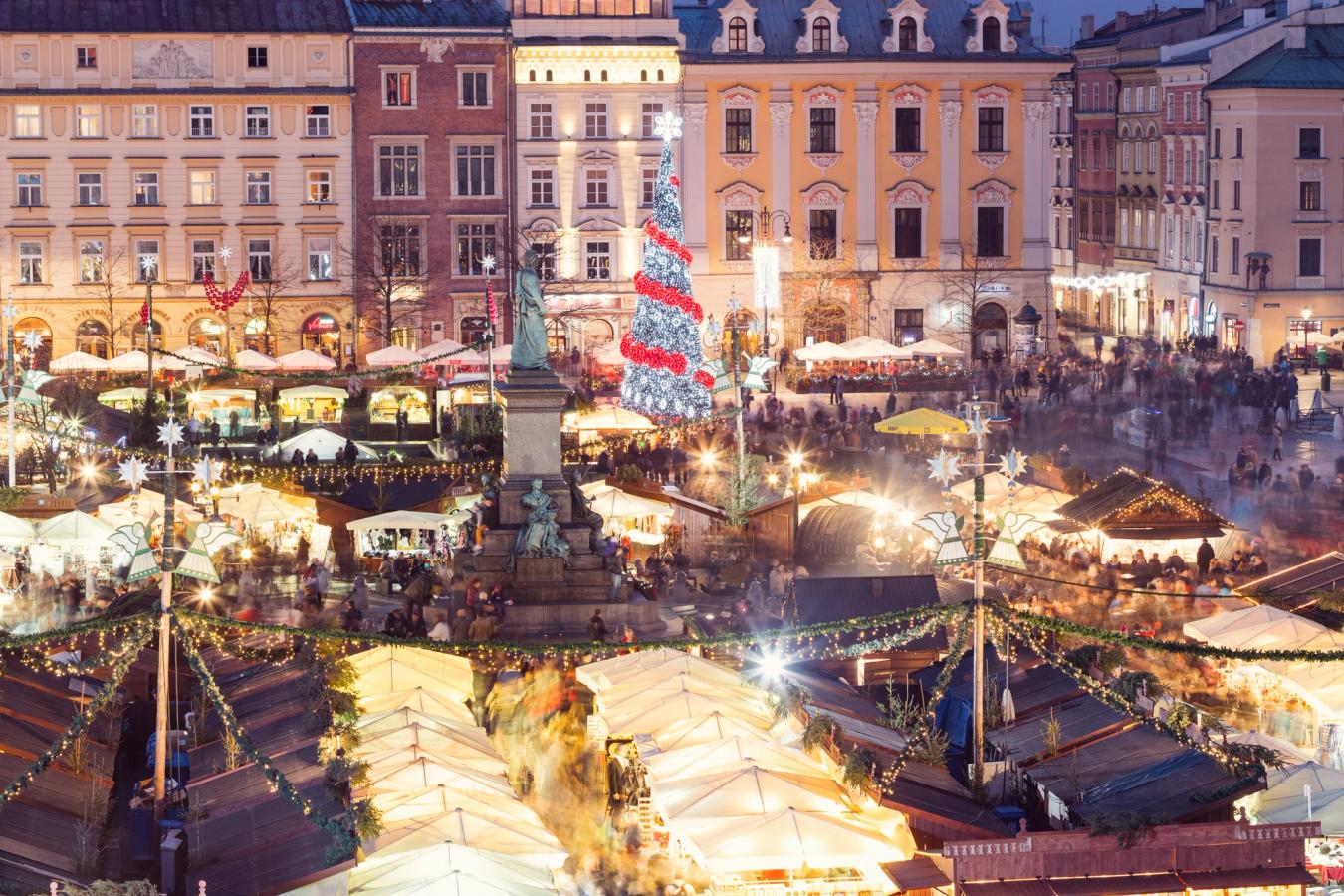 Bilden visar en julmarknad i Krakow med matbodar, julbelysning och serveringstält