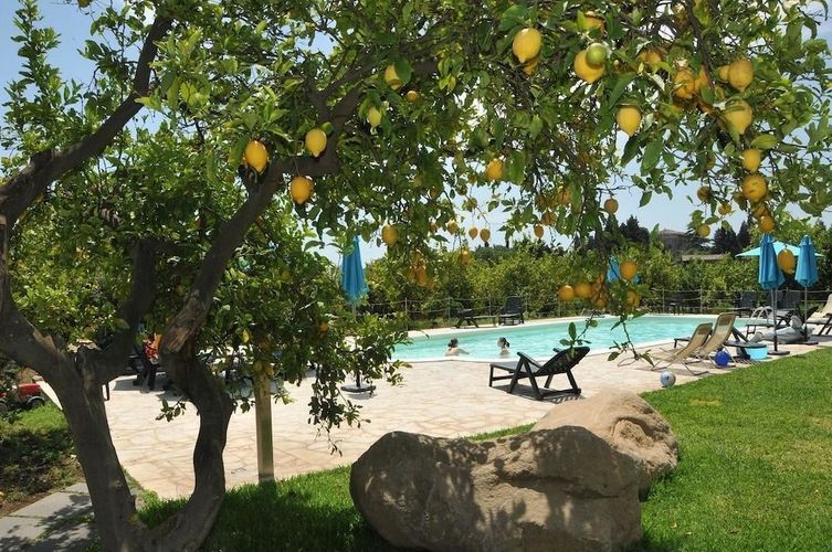 Slap af ved poolen omgivet af citrontræer på Agriturismo San Leonardello på Sicilien.