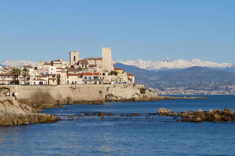 Utsikt til gamlebyen i Antibes med snødekte fjell i horisonten på den franske riviera
