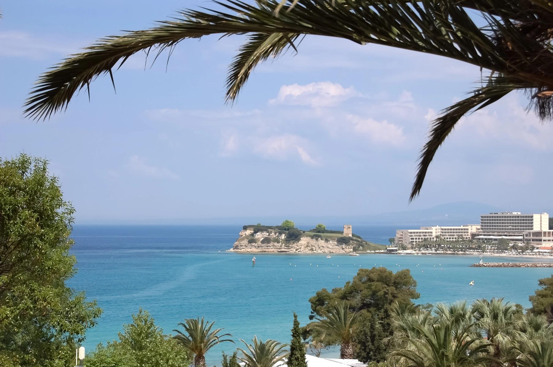 Utsikt over det krystallklare havet med palmer, strand og hoteller i Cap Sani i Halkidiki, Hellas