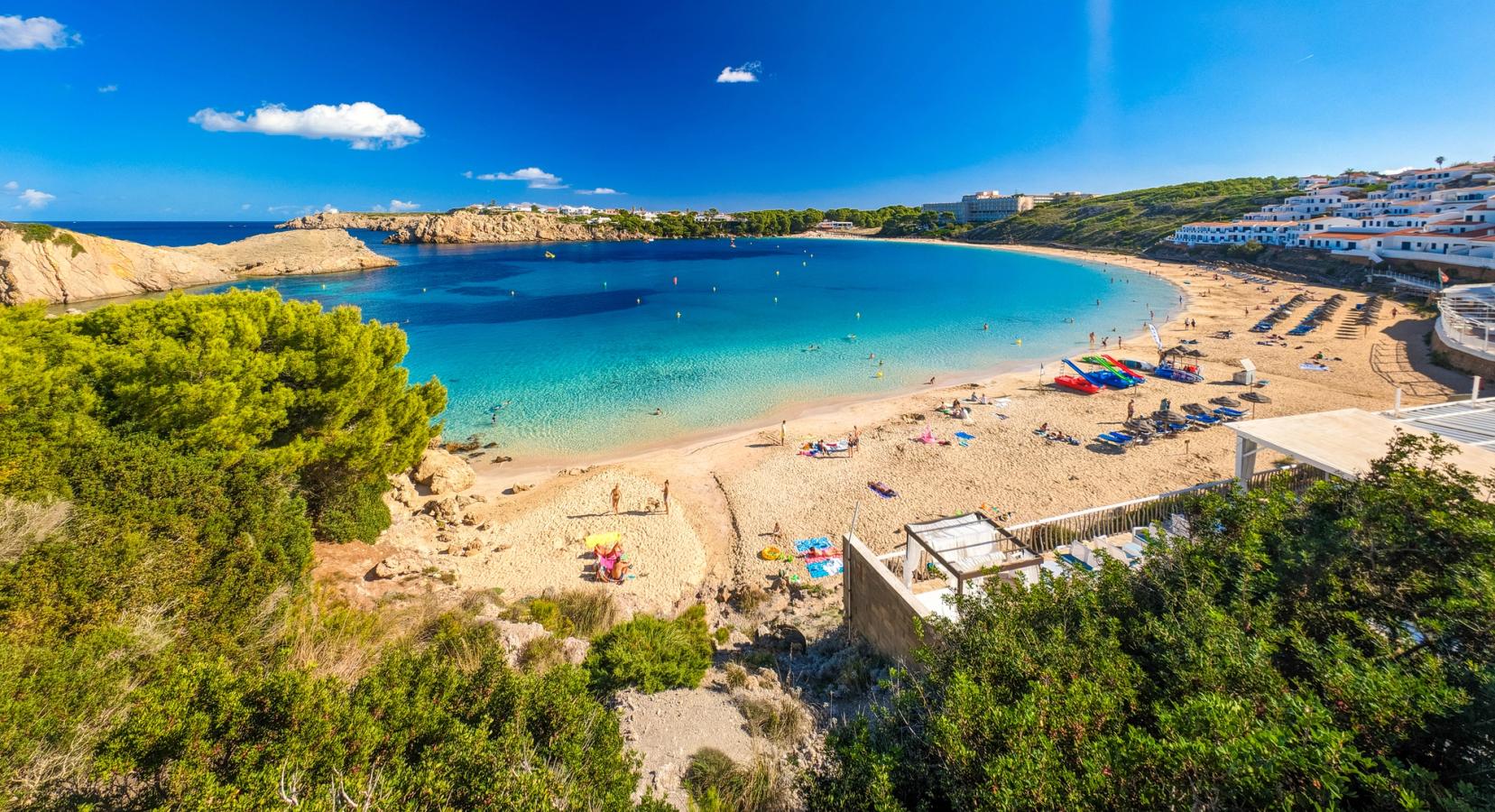 Bilden visar bukten i Arenal d’en Castell med stranden och det klara blå havet