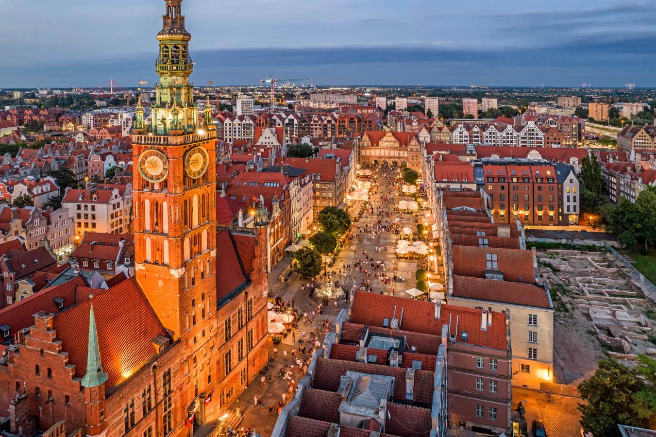Bildet viser Long Market Street i Gdansk, sett ovenifra. Først i bildet, på venstre side, ser vi Main City Hall med kveldsopplyst gate og fullt av mennesker