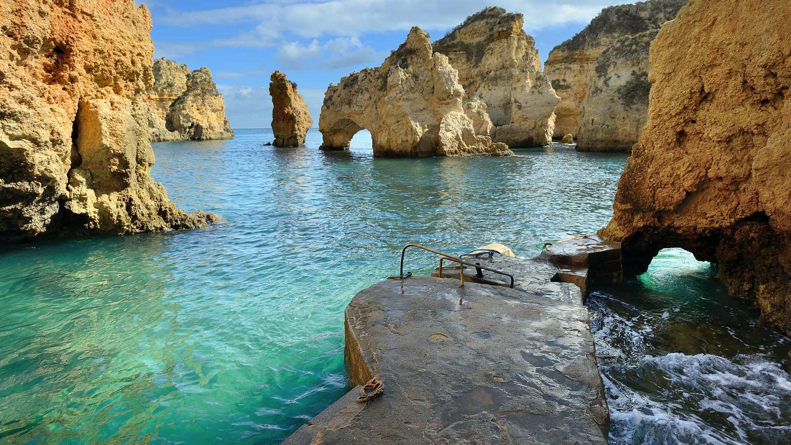 Klart blått hav med flere stein- og klippeformasjoner i vannet