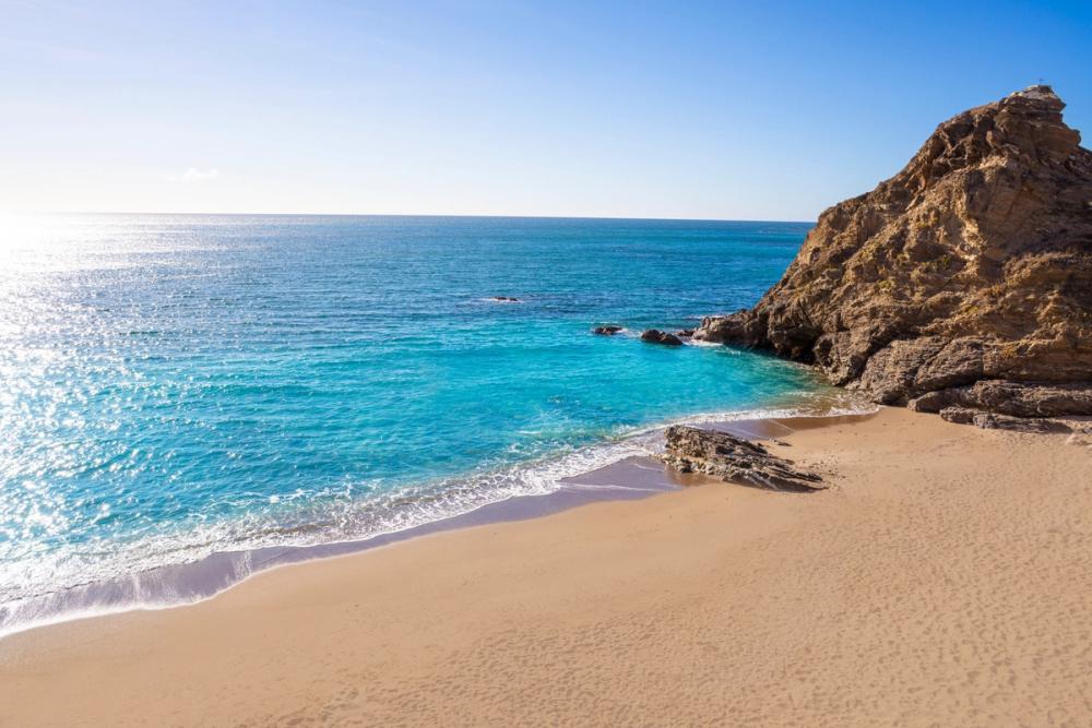 Viser stranden Playa Piedras del Cura med rolig sjø. Rett ved Mijas på Costa del Sol