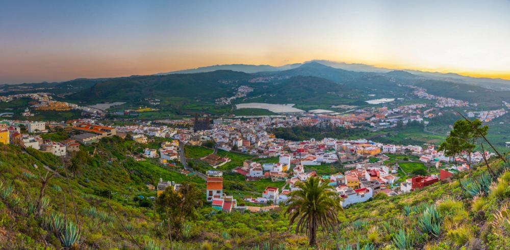 Udsigt over Arucas på Gran Canaria omkranset af smuk, grøn natur i solnedgang