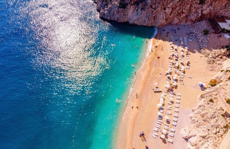 Panoramautsikt over en deilig sandstrand og azurblått hav i Antalya i Tyrkia