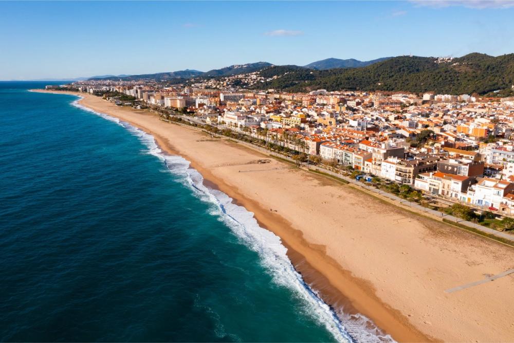Panoramautsikt over den flotte, langstrakte stranden i Malgrat de Mar på Costa Brava i Spania