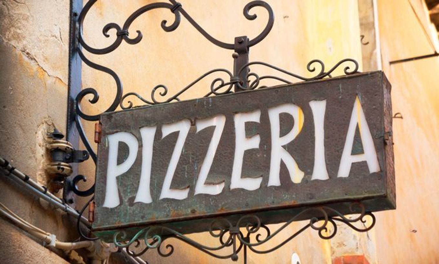 Skilt som viser vei til en pizzeria