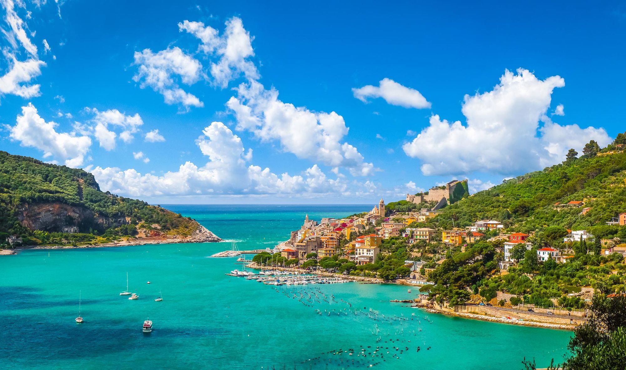 Utsikt over det turkise havet, grønne landskapet og en landsby i Liguria i Italia