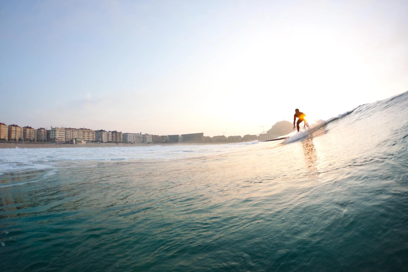 Bildet viser en surfer på vei inn mot stranda i San Sebastian