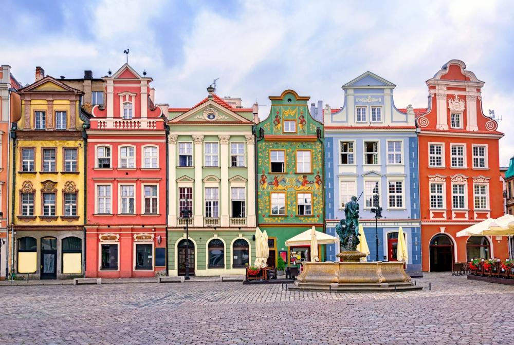 Bildet viser klassiske gamlebyen i Poznan. Smale og fargerike bygninger i eldre arkitektur med en brosteinsbelagt torgplass.