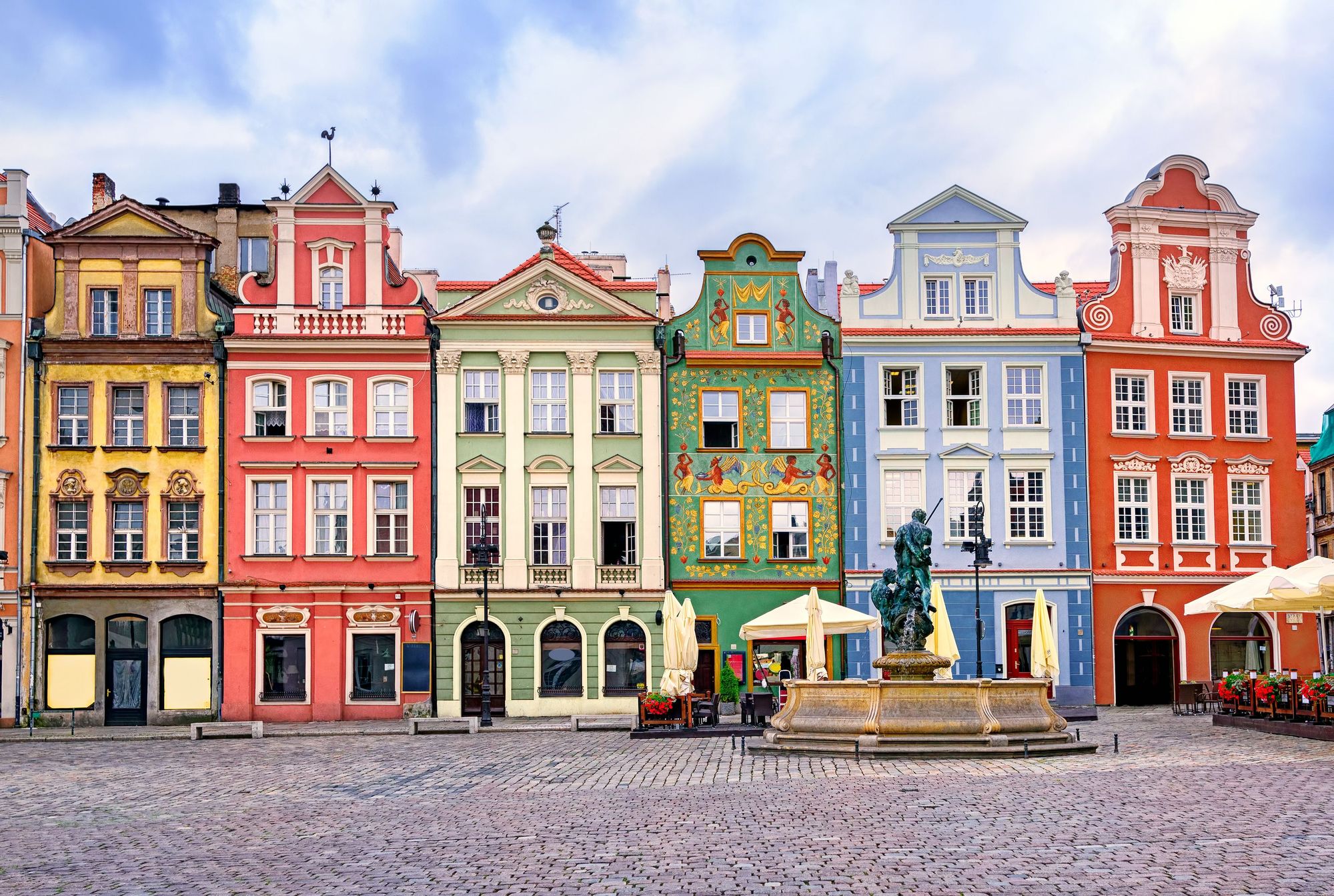 Bildet viser klassiske gamlebyen i Poznan. Smale og fargerike bygninger i eldre arkitektur med en brosteinsbelagt torgplass.