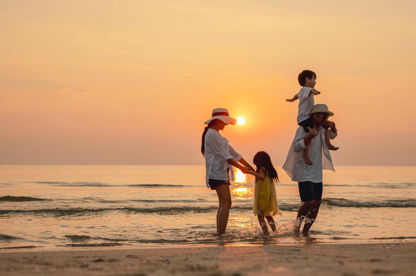 Vacker solnedgång med familjen på stranden i Thailand