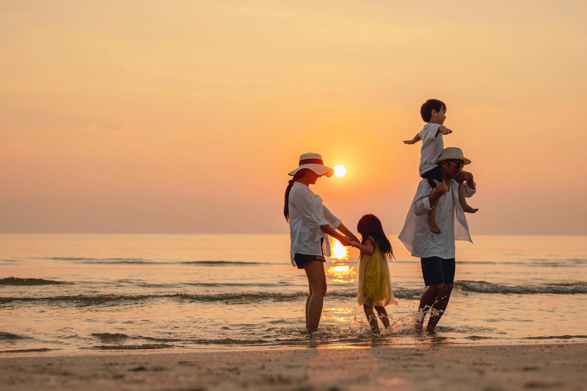 Smuk solnedgang med familien på stranden i Thailand