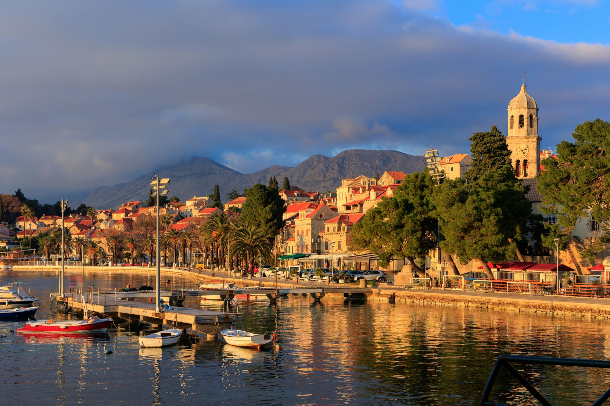 Lille havn med små både. I baggrunden ses Cavtat, byens kirke og bjergene der omgiver byen. 