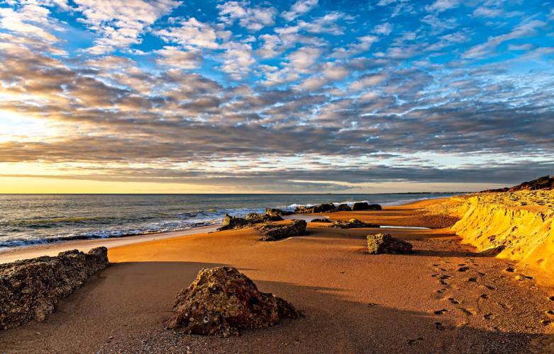 Solnedgang lager varme farger over stranden ved Conil de la Frontera