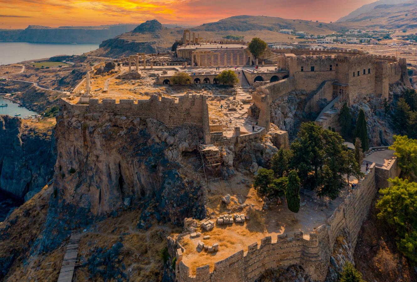 Panoramautsikt över Akropolis i Lindos på Rhodos, som ligger på toppen av en klippa med fantastisk utsikt över bergen och havet i solnedgången