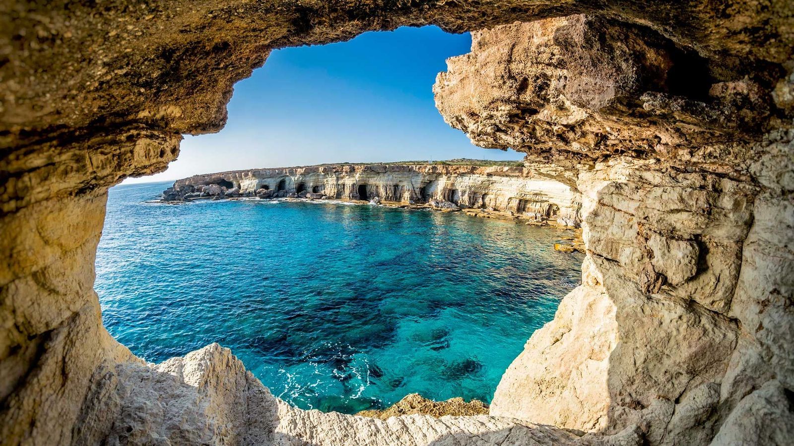 Cape Greco nasjonalpark på Kypros med dramatiske klipper og grotter og krystallklart hav