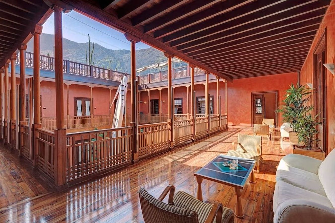 Ett atrium på Hotel San Roque i Garachico på Teneriffa. Väggarna är rödbruna, medan golvet och bärande konstruktioner i övrigt är av trä.
