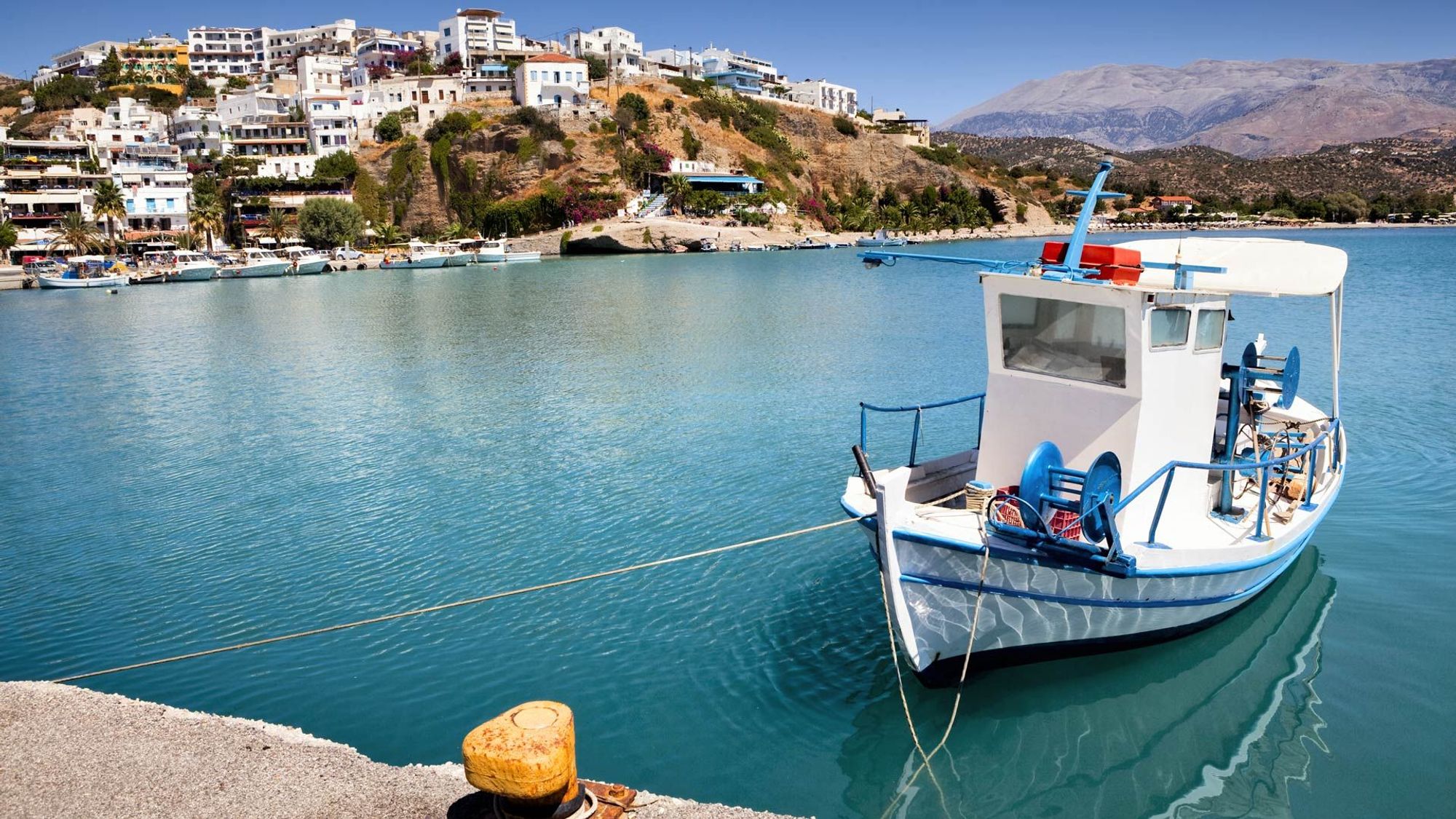 En lokal fiskebåt med utsikt til den idylliske småbyen Agia Galini på Kreta