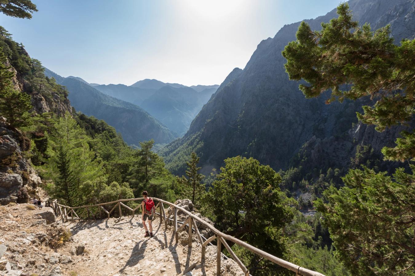 En dame på fottur langs Samaria-ravinen på Kreta. Tilrettelagt tursti og en vakker utsikt over naturen og fjellene på en strålende fin solskinnsdag