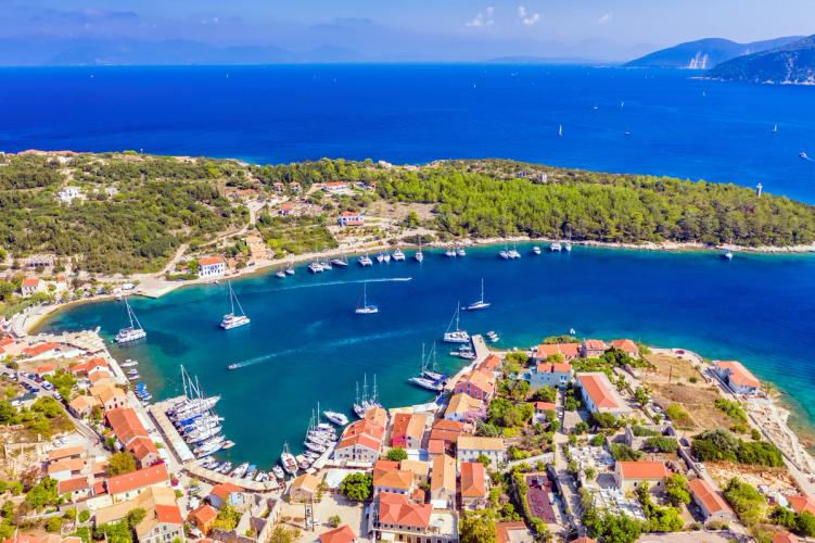 Panoramaudsigt over havet, den idylliske by og den lille lystbådehavn i Fiskardo på Kefalonia i Grækenland