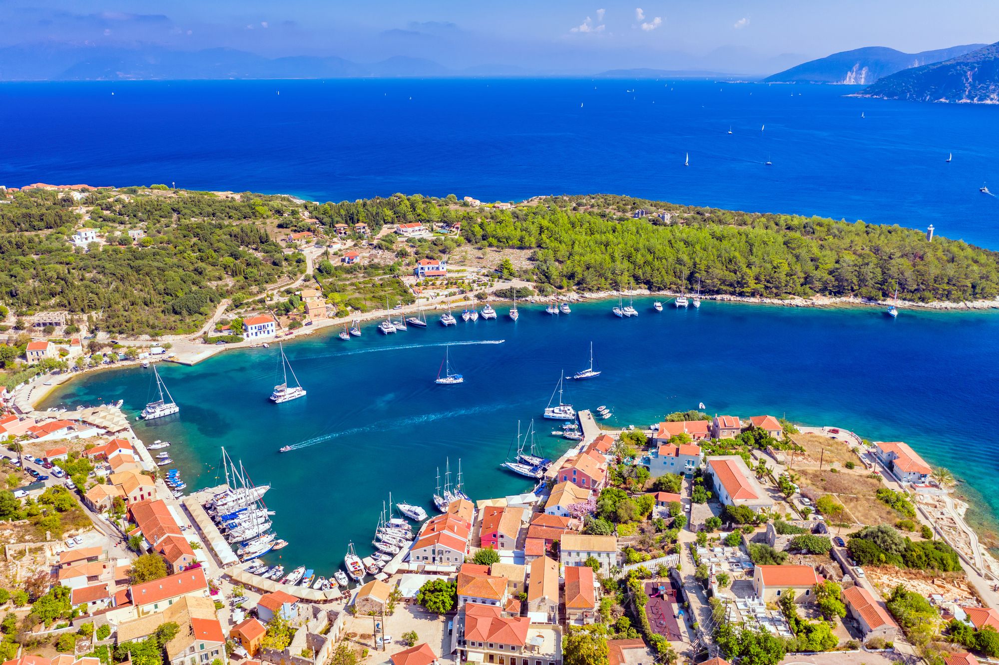 Panoramaudsigt over havet, den idylliske by og den lille lystbådehavn i Fiskardo på Kefalonia i Grækenland