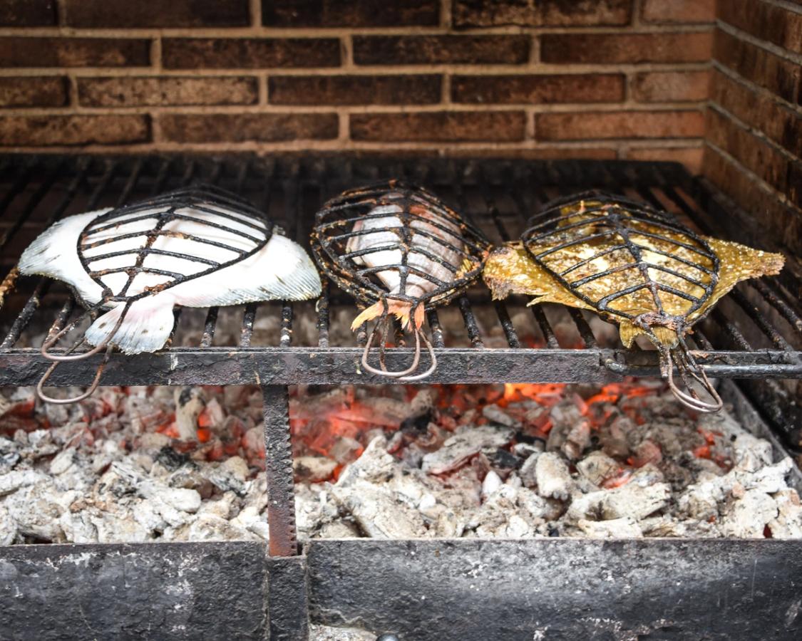Bilden visar färsk piggvar (Rodaballo) som grillas på traditionellt vis i Getaria. På ett galler över glödande kol.