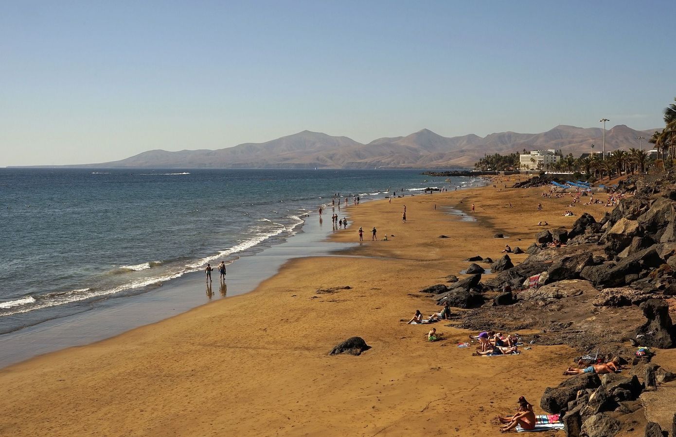 Langstrakte strender med mørk lavasand i Puerto del Carmen på Lanzarote 