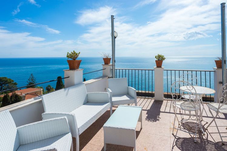 På Elios Hotel i Taormina kan du slappe av på terrassen med utsikt mot havet.