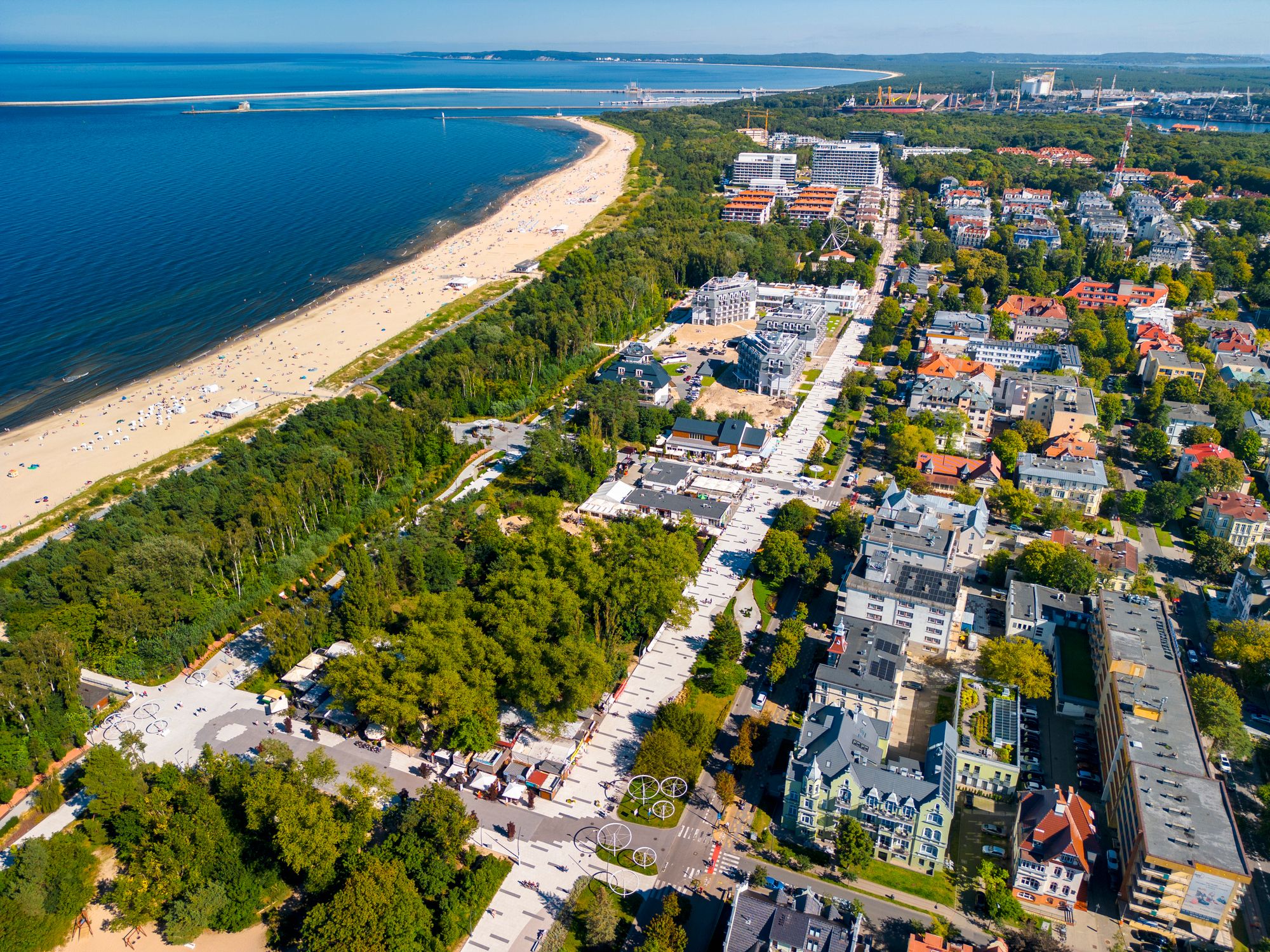 Billedet viser stranden langs Swinoujscie i Polen. Til venstre i billedet ses stranden og havet, mens vi til højre ser mere af byens bebyggelse blandet med små skovområder.