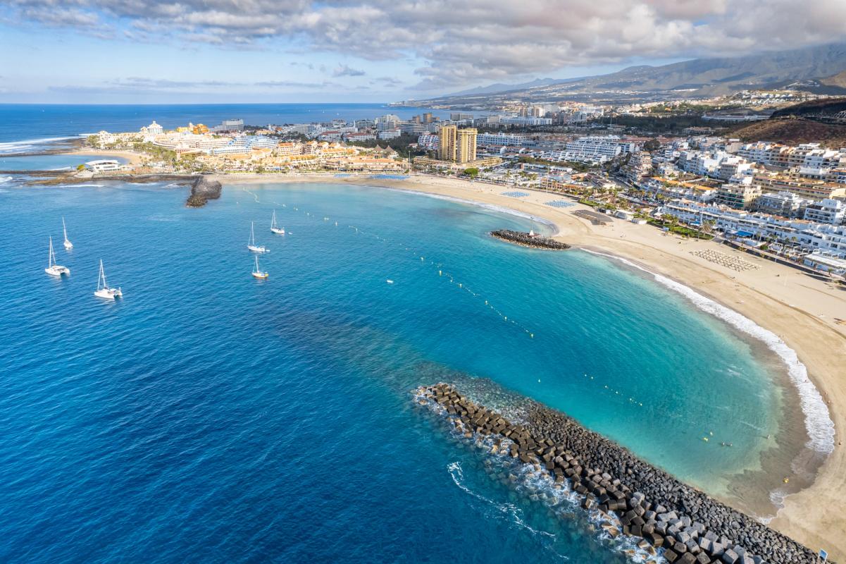 Bildet viser stranden og bukten foran byene Los Cristianos og Playa de las Americas