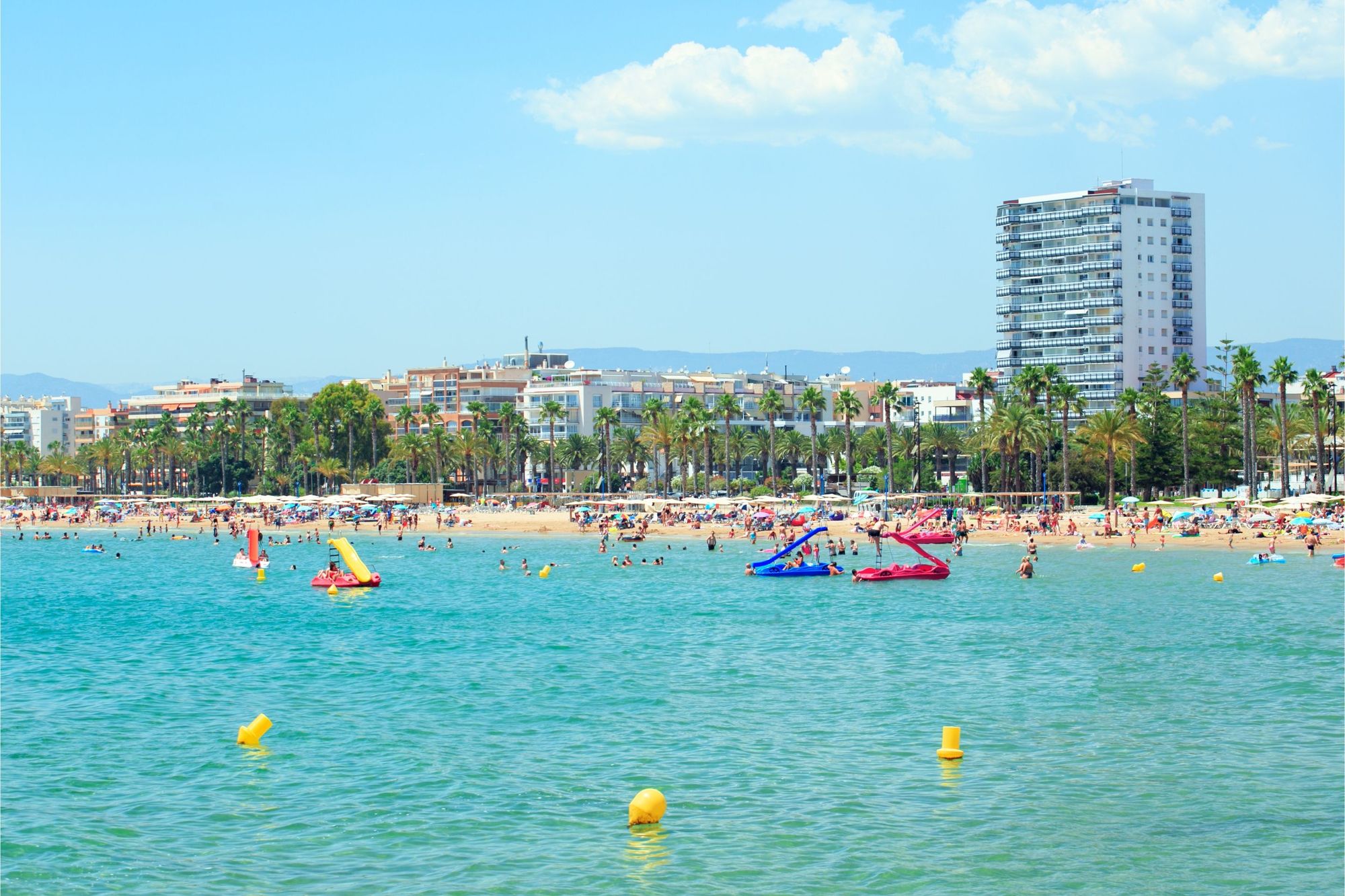 Utsikt over stranden med badegjester og vannsportaktiviteter i Salou på Costa Dorada i Spania