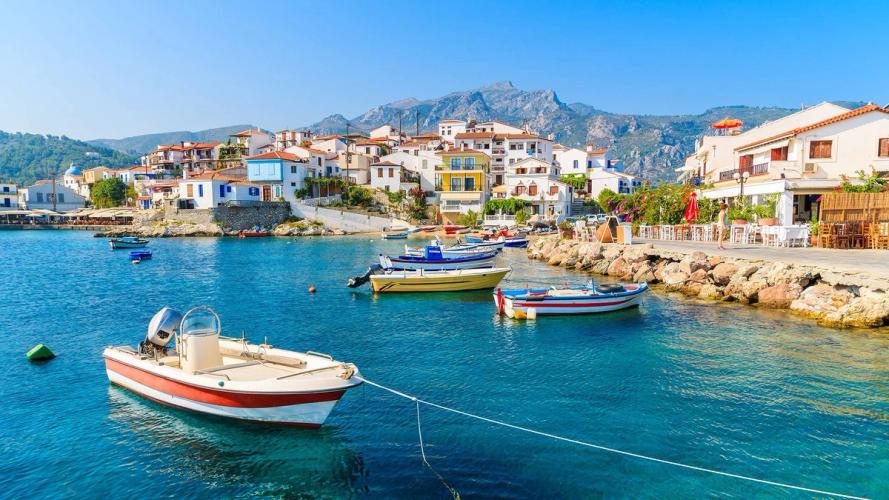 Udsigt over byen Kokkari på Samos med krystalklart vand og små både