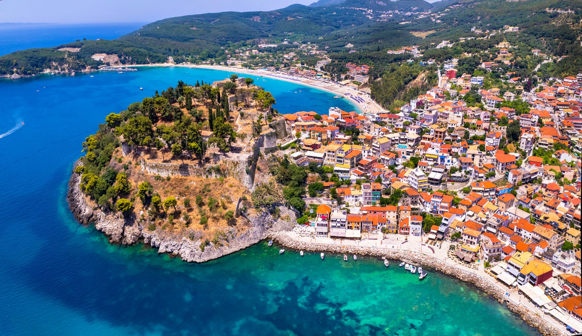 Panoramautsikt över staden Parga och de färgglada husen, med den barnvänliga stranden Valtos i horisonten