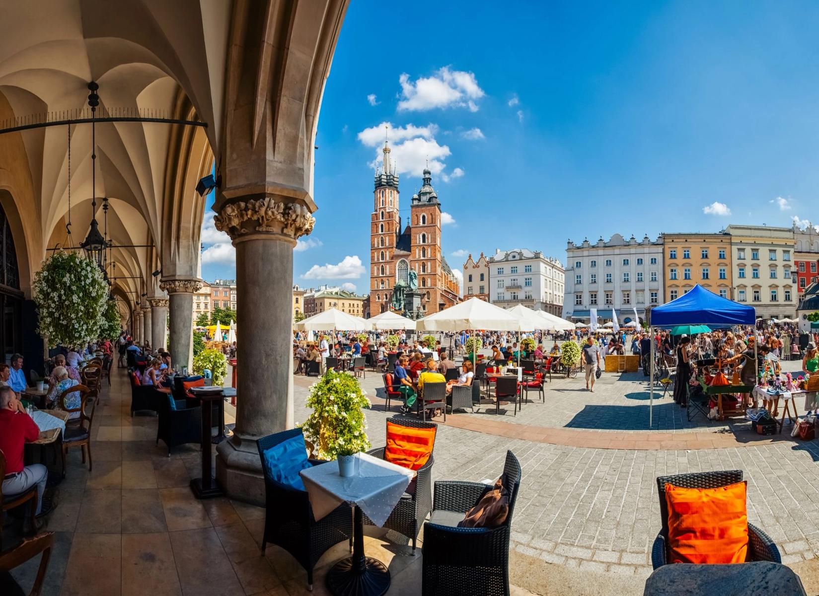 Bildet viser et åpent torg i Krakow under en skyfri himmel.