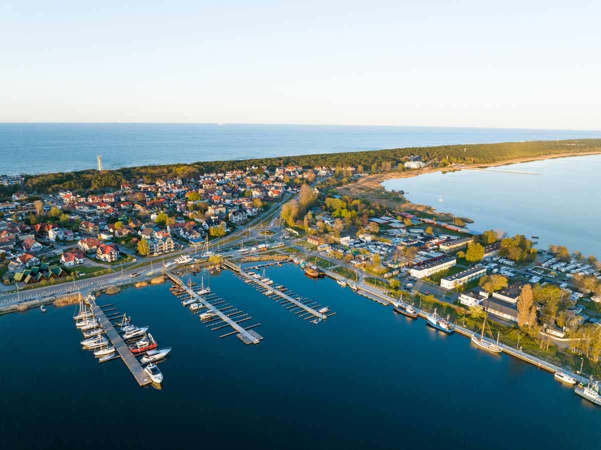 Jastarnia sett fra luften. I forgrunnen ses byens småbåthavn og flere hus med røde tegltak. I bakgrunnen går vannet i ett med horisonten.