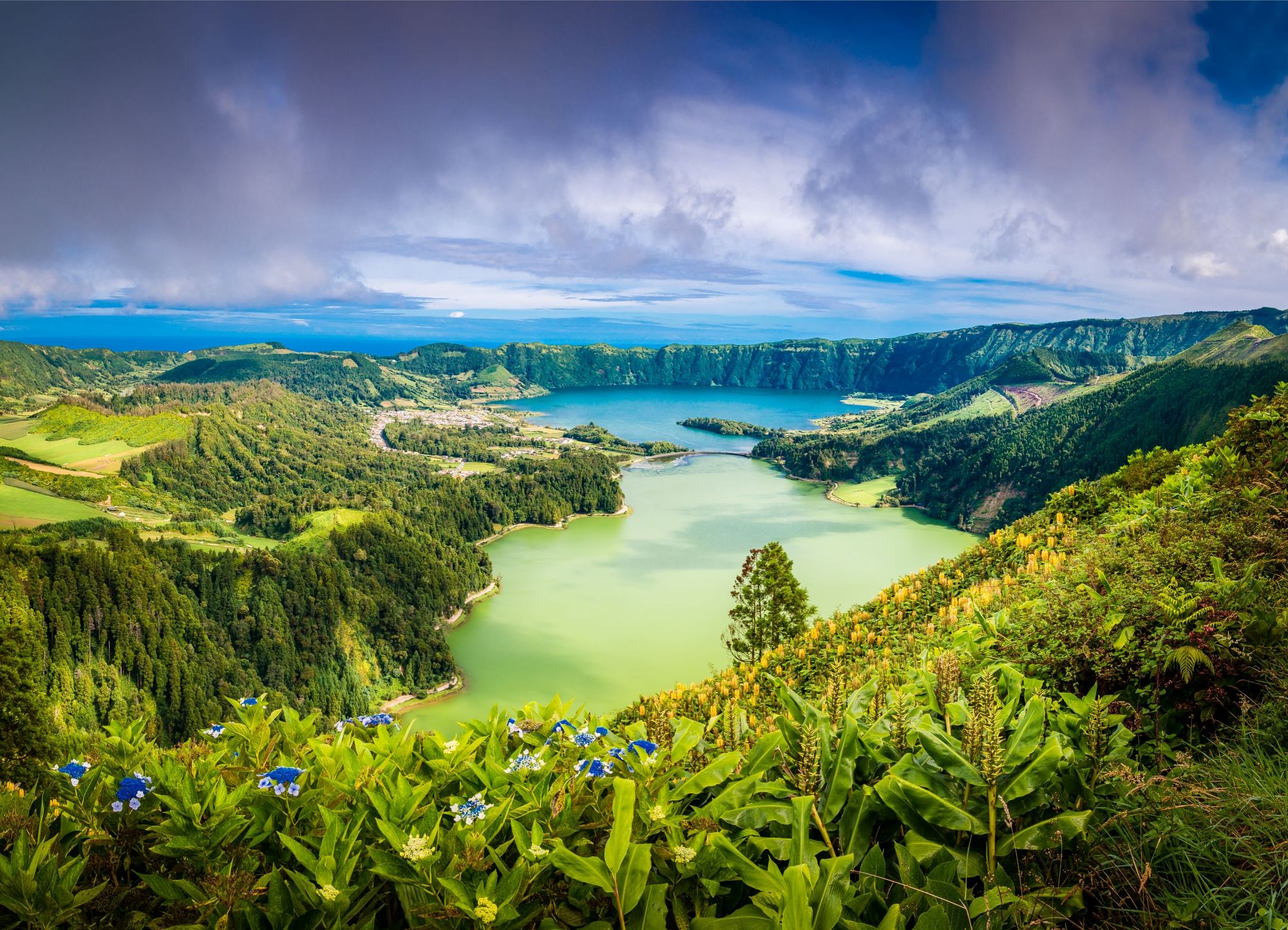 Utsikt over Sete Cidades-krateret på Azorene, med grønne og blå innsjøer omkranset av fjell.