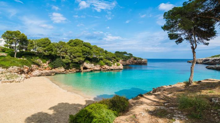Sandstrand og blått hav fra en bukt ved Cala d´Or på Mallorca