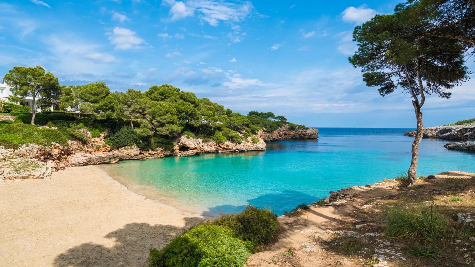 Billedet viser en indbydende badebugt med turkisblåt vand ved lille Cala d´Or på østsiden af Mallorca.