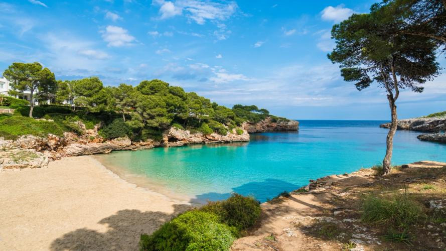 Sandstrand og blåt hav fra en bugt ved Cala d'Or på Mallorca