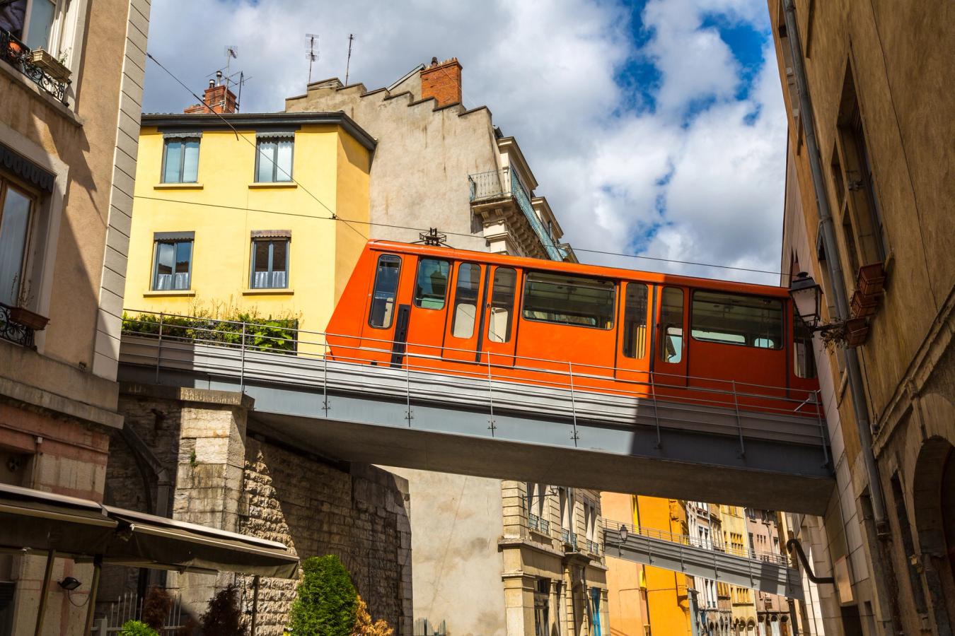 En rød kabelbane kører op mellem husene i Lyon.