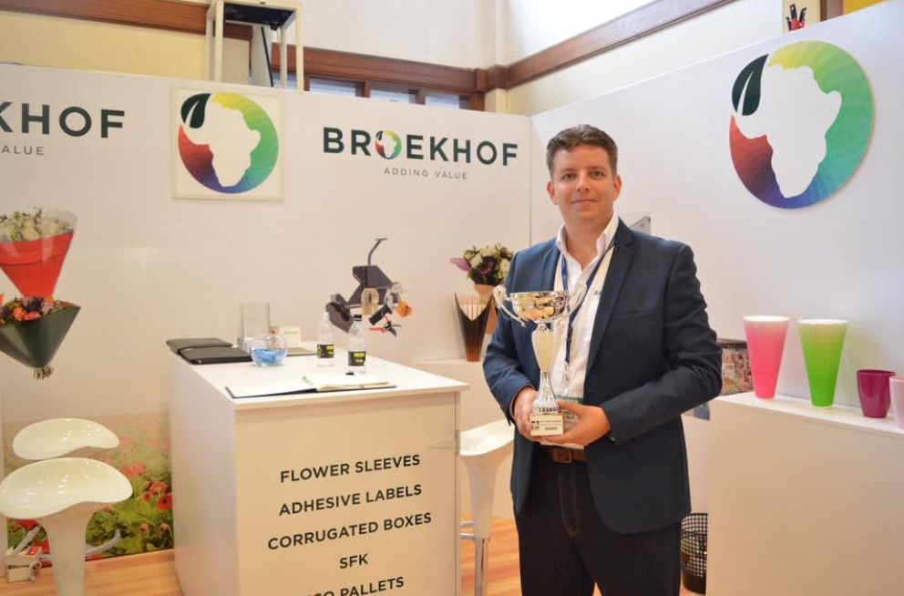 A man holding a trophy at the Broekhof exhibition stand